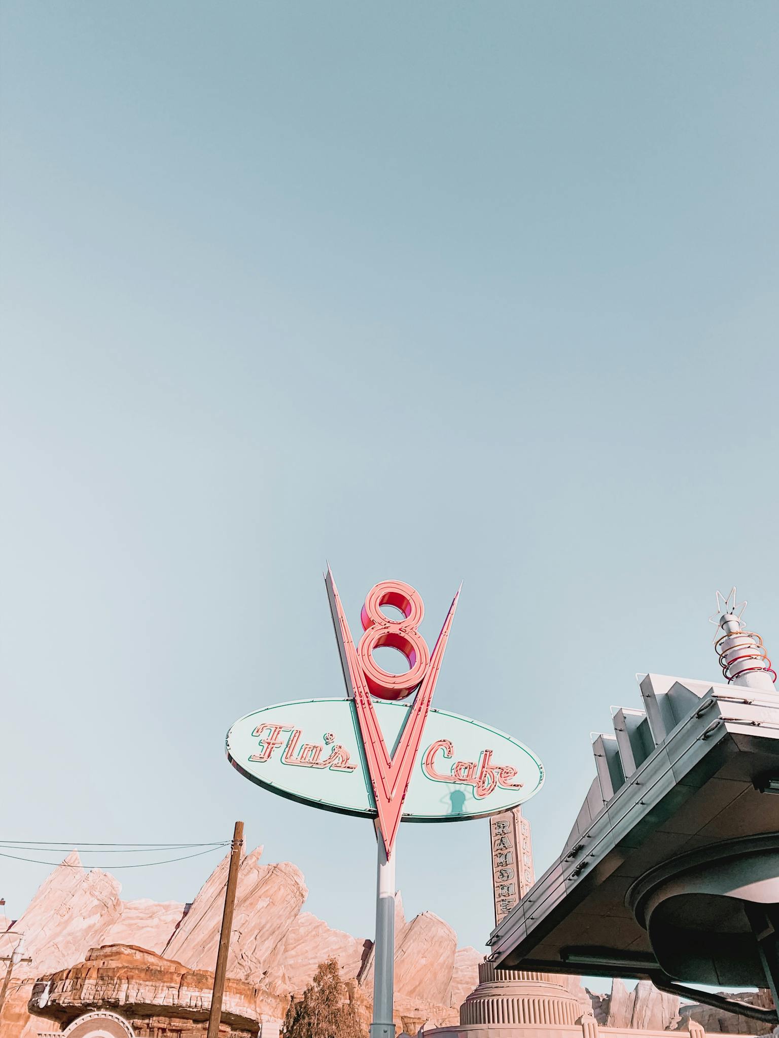 Low angle shot of the iconic Flo's V8 Cafe sign under a clear sky in Disneyland.